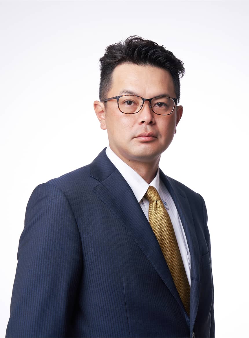 作業服姿で腕を組み笑顔を見せる男性社員