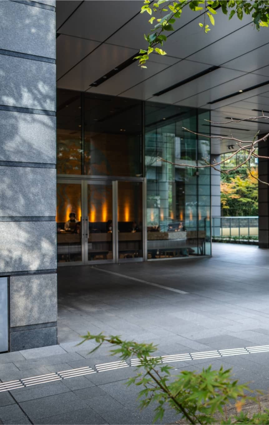 屋根付きの広いビル前通路とガラス張りの玄関